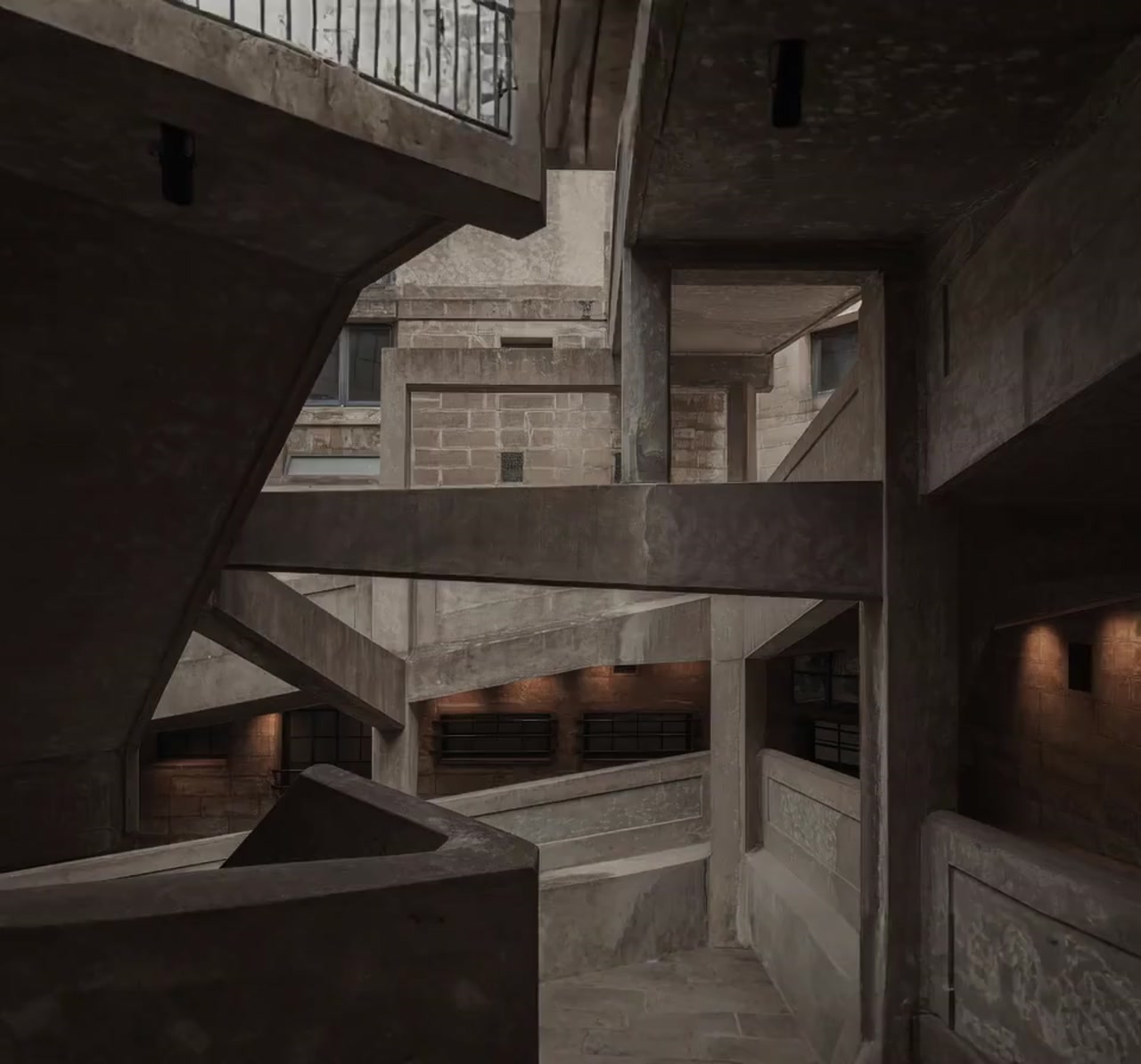 Wnętrze budynku o brutalistycznej, betonowej architekturze z ciepłym oświetleniem widocznym w głębi